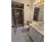 Bathroom with a walk-in shower, white tile floors, and well-lit vanity space at 12809 Wedgewood Way # A, Hudson, FL 34667