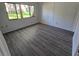 Cozy bedroom features wood-look flooring and a large window with serene views at 12809 Wedgewood Way # A, Hudson, FL 34667