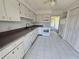 Clean kitchen features white cabinetry, appliances, tile flooring and a view to the patio at 12809 Wedgewood Way # A, Hudson, FL 34667