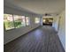 Spacious living room showcasing wood floors and ample natural light from large windows at 12809 Wedgewood Way # A, Hudson, FL 34667