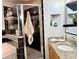 Modern bathroom with a glass-enclosed shower, granite countertop vanity, and a decorative mirror at 1418 Buckner Rd, Valrico, FL 33596