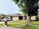 Charming brick home with a well-manicured lawn, two-car garage, and attractive landscaping at 1418 Buckner Rd, Valrico, FL 33596