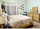 Well-lit bedroom with a comfortable bed, wooden furniture, and sheer curtains at 1418 Buckner Rd, Valrico, FL 33596