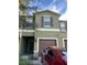 View of the two-story townhouse with a well-maintained lawn and a parked car out front at 1438 Mallory Sail Pl, Brandon, FL 33511