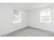 Bright bedroom with two windows offering natural light and modern gray wood flooring at 1513 Escort Ave, Tampa, FL 33610