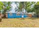 Charming blue home with stone accents, well-maintained lawn and mature trees at 1513 Escort Ave, Tampa, FL 33610