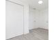 Hallway with multiple white doors and closets, enhanced by modern gray wood flooring at 1513 Escort Ave, Tampa, FL 33610
