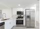 Bright kitchen features stainless steel appliances, white cabinets, and modern countertops at 1513 Escort Ave, Tampa, FL 33610