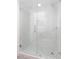 Elegant glass shower enclosure with white marble tiling and a stylish black and white mosaic floor at 1513 Escort Ave, Tampa, FL 33610