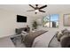 Cozy bedroom featuring stylish decor, a ceiling fan, and a flat-screen TV for comfortable living at 16717 Myrtle Sand Dr, Wimauma, FL 33598