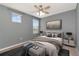 Stylish bedroom features a ceiling fan and decor with a picture window and bedside tables at 16717 Myrtle Sand Dr, Wimauma, FL 33598