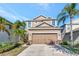 Two-story home featuring a two-car garage, stone accents and tropical landscaping at 16717 Myrtle Sand Dr, Wimauma, FL 33598