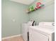 Laundry room featuring a white washer and dryer with wall-mounted shelf at 16717 Myrtle Sand Dr, Wimauma, FL 33598
