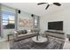 Bright living room featuring neutral decor, large windows, and a ceiling fan at 16717 Myrtle Sand Dr, Wimauma, FL 33598