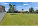 Expansive backyard featuring lush lawn with mature landscaping, and fenced perimeter at 1806 Mira Lago Cir, Ruskin, FL 33570
