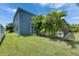 Backyard with lush grass, a screened in pool, and a partial view of a blue house at 1806 Mira Lago Cir, Ruskin, FL 33570