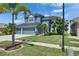 Charming blue two-story home with a well-manicured lawn, lush landscaping, and a convenient three-car garage at 1806 Mira Lago Cir, Ruskin, FL 33570