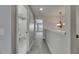 Hallway with an elegant chandelier and views into the bathroom and bedroom at 1806 Mira Lago Cir, Ruskin, FL 33570