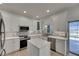 Well-equipped kitchen offers stainless steel appliances, white cabinetry, and a kitchen island with a water view at 1806 Mira Lago Cir, Ruskin, FL 33570