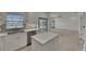 Modern kitchen features white cabinets, stainless steel appliances, and an island with quartz countertops at 1806 Mira Lago Cir, Ruskin, FL 33570