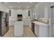 Stylish kitchen with stainless steel appliances, ample white cabinets, and a kitchen island with quartz countertops at 1806 Mira Lago Cir, Ruskin, FL 33570