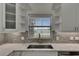 This view shows a kitchen sink that overlooks a pool, lots of storage, and a stylish backsplash at 1806 Mira Lago Cir, Ruskin, FL 33570