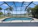 Inviting screened-in pool with beautiful lake view and palm trees at 1806 Mira Lago Cir, Ruskin, FL 33570
