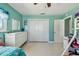 Bedroom with large closet, bureau, terrazzo flooring, and teal colored walls at 18102 2Nd St E, Redington Shores, FL 33708