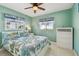 Cozy bedroom featuring two windows, a queen bed, and a white dresser at 18102 2Nd St E, Redington Shores, FL 33708