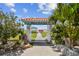 Surfside Beach Club entry gate surrounded by lush landscaping and inviting gazebo at 18102 2Nd St E, Redington Shores, FL 33708