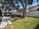 Spacious backyard with lush green grass, stone patio, gazebo, and large shade trees at 1830 Citrus Orchard Way, Valrico, FL 33594
