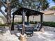 Relaxing backyard gazebo featuring a fire pit and comfortable seating on a gray stone paver patio at 1830 Citrus Orchard Way, Valrico, FL 33594