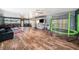 Large recreation room with hardwood floors, offering a home gym, comfortable seating, and a trampoline at 1830 Citrus Orchard Way, Valrico, FL 33594