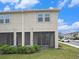 Back of home featuring screened patios, well maintained lawn, and manicured bushes at 19153 Elsimont Isle, Lutz, FL 33558