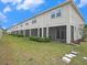 Back of home featuring screened patios, well maintained lawn, and stepping stones at 19153 Elsimont Isle, Lutz, FL 33558