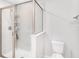 Bright bathroom featuring a glass shower, toilet, and tiled walls at 19153 Elsimont Isle, Lutz, FL 33558