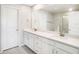 Bathroom featuring double sinks, white cabinets, and a large mirror at 19153 Elsimont Isle, Lutz, FL 33558