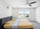 Bright bedroom with double windows, a queen bed and stylish ceiling fan at 19153 Elsimont Isle, Lutz, FL 33558