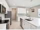 Modern kitchen featuring stainless steel appliances, white cabinetry, and a stylish tiled backsplash at 19153 Elsimont Isle, Lutz, FL 33558