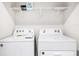 Functional laundry area featuring a washer, dryer, and shelving for storage at 19153 Elsimont Isle, Lutz, FL 33558