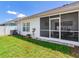 Fenced backyard with healthy green lawn and the back of the house with screened-in porch at 19337 Weymouth Dr, Land O Lakes, FL 34638