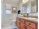 Bathroom featuring a granite vanity with wooden cabinets, a framed mirror, and a toilet at 19337 Weymouth Dr, Land O Lakes, FL 34638