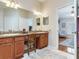 Bathroom featuring double sinks, granite countertop, walk-in shower with glass door, and vanity seating at 19337 Weymouth Dr, Land O Lakes, FL 34638
