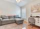 Comfortable bedroom area with a gray sofa, office desk, and natural light at 19337 Weymouth Dr, Land O Lakes, FL 34638