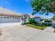Well-maintained single-story home featuring a two-car garage and neatly trimmed bushes underneath a sunny sky at 19337 Weymouth Dr, Land O Lakes, FL 34638