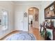 Foyer showcasing decorative front door, hardwood floors, arched doorways, and stylish accents at 19337 Weymouth Dr, Land O Lakes, FL 34638