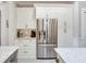 Kitchen with stainless steel refrigerator, white cabinets, granite countertops and breakfast bar at 19337 Weymouth Dr, Land O Lakes, FL 34638