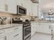Updated kitchen features stainless steel appliances, modern cabinets, quartz counters, and stylish backsplash at 19337 Weymouth Dr, Land O Lakes, FL 34638