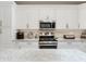 Updated kitchen with stainless oven and microwave, tile backsplash, and granite countertops at 19337 Weymouth Dr, Land O Lakes, FL 34638