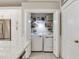 Conveniently located laundry room with washer, dryer, storage shelves, and adjacent kitchen cabinetry at 19337 Weymouth Dr, Land O Lakes, FL 34638